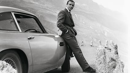 Sean Connery leaning on an Aston Martin DB5