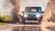 Suzuki Jimny splashing through mud