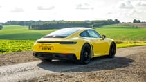 Porsche 911 Carrera 4 GTS coupe yellow rear three quarter