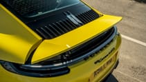 Porsche 911 Carrera 4 GTS coupe yellow rear spoiler activated