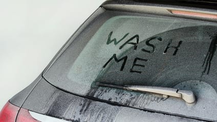 Close up of rear windscreen with 'Wash Me' written in the dirt