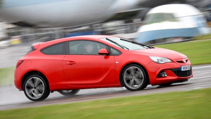 Profile driving shot of red Vauxhall Astra at aerodrome track