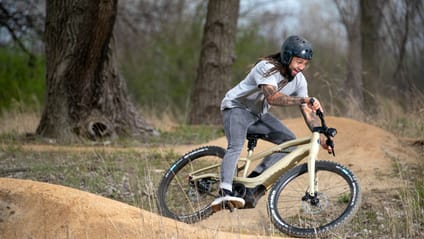 Guy in helmet rides Serial Bash electric bike, powered by Harley Davidson, on uneven terrain