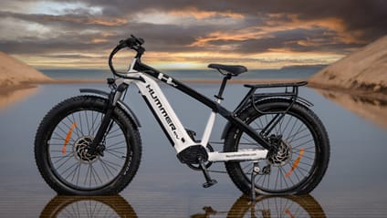 A profile shot with Hummer EV ebike in foreground and sunset backdrop