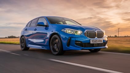 Driving shot of BMW 1 Series M Sport taken from drivers side front with setting sun behind