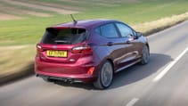 Rear driving shot of Ford Fiesta on country road in sun