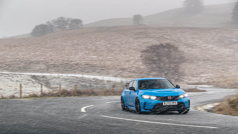 Blue Honda Civic Type R driving shot zoomed out on a foggy frosty day