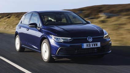 Driving shot of VW Golf in dark blue on sunny day