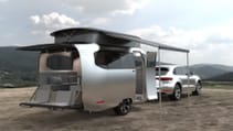 Landscape shot of Airstream Studio Porsche travel trailer concept with pop top popped and rear doors dropped