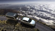 Render of an Airstream Studio Porsche Travel Trailer concept driving on a winding road above clouds