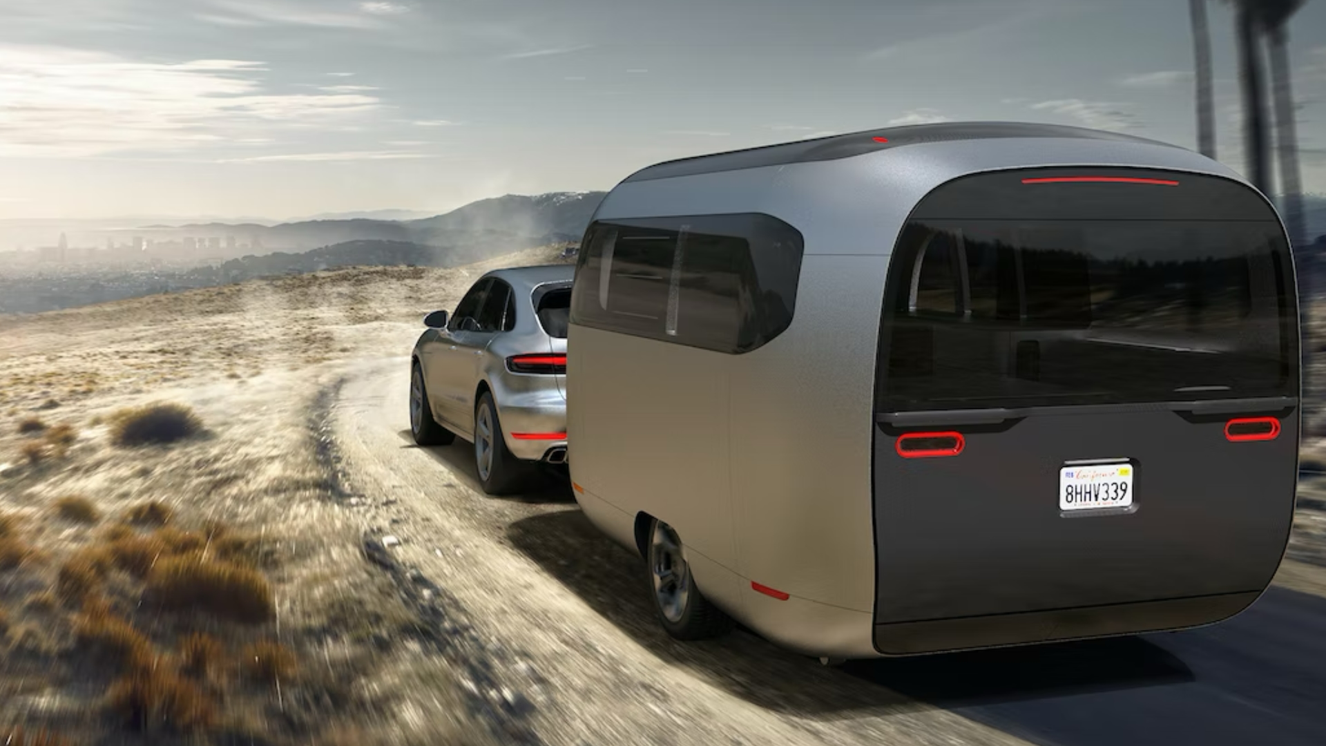 Driving shot of Airstream Studio Porsche travel trailer concept in desert landscape