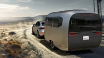 Driving shot of Airstream Studio Porsche travel trailer concept in desert landscape