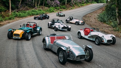 Seven Caterhams coming around a track corner in formation