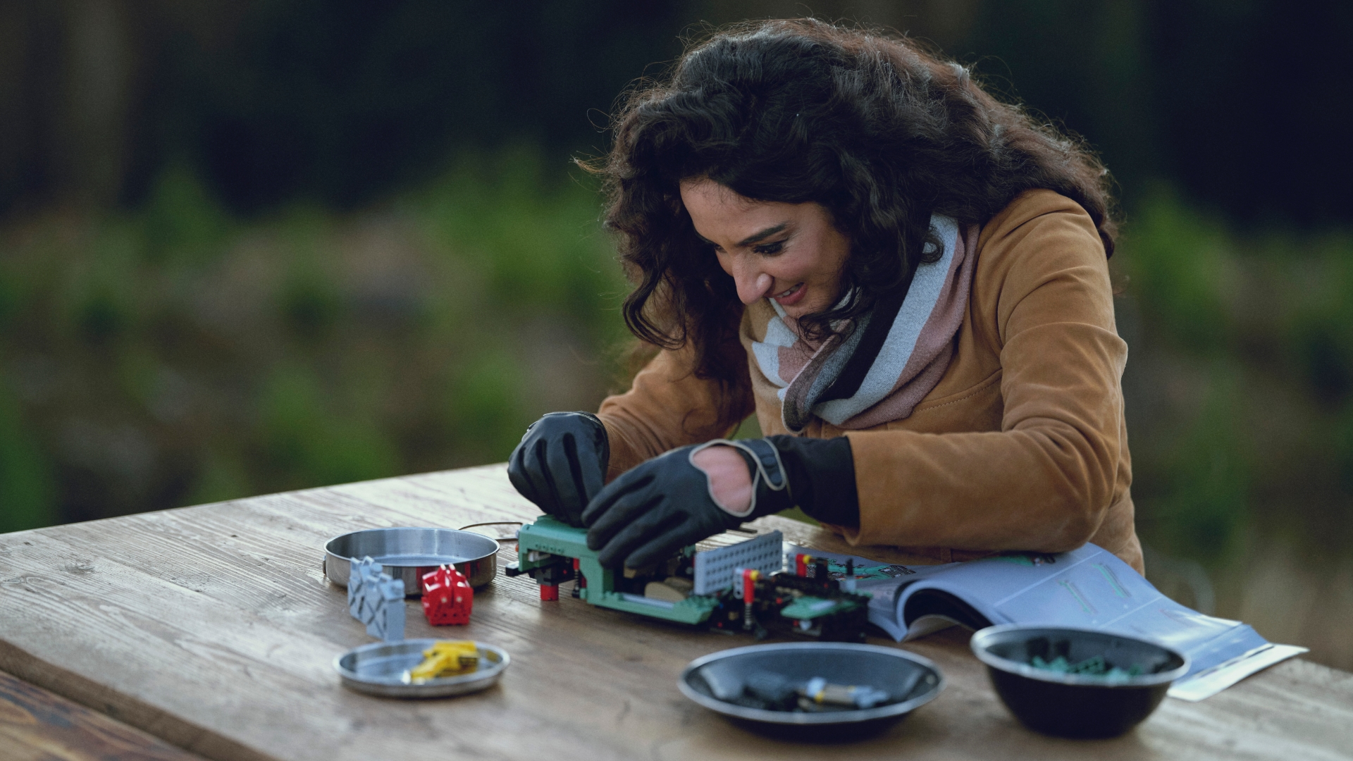 Raha Moharrak, first Saudi woman to climb Everest, sits on picnic bench building new Lego classic Land Rover Defender 90