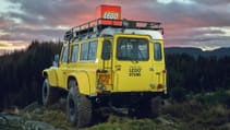 Full-sized classic Land Rover Defender 90 mocked up in yellow with a Lego box on top, denoting 'world's most remote Lego store'