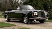 Gleaming black Rolls-Royce Silver Shadow parked on a gravel drive