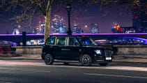 Driving shot of LEVC TX on Embankment alongside river Thames at night with OXO tower in distance