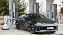 Hyundai IONIQ 6 parked at a charging hub with a robot charger connecting the cable to the car without humans