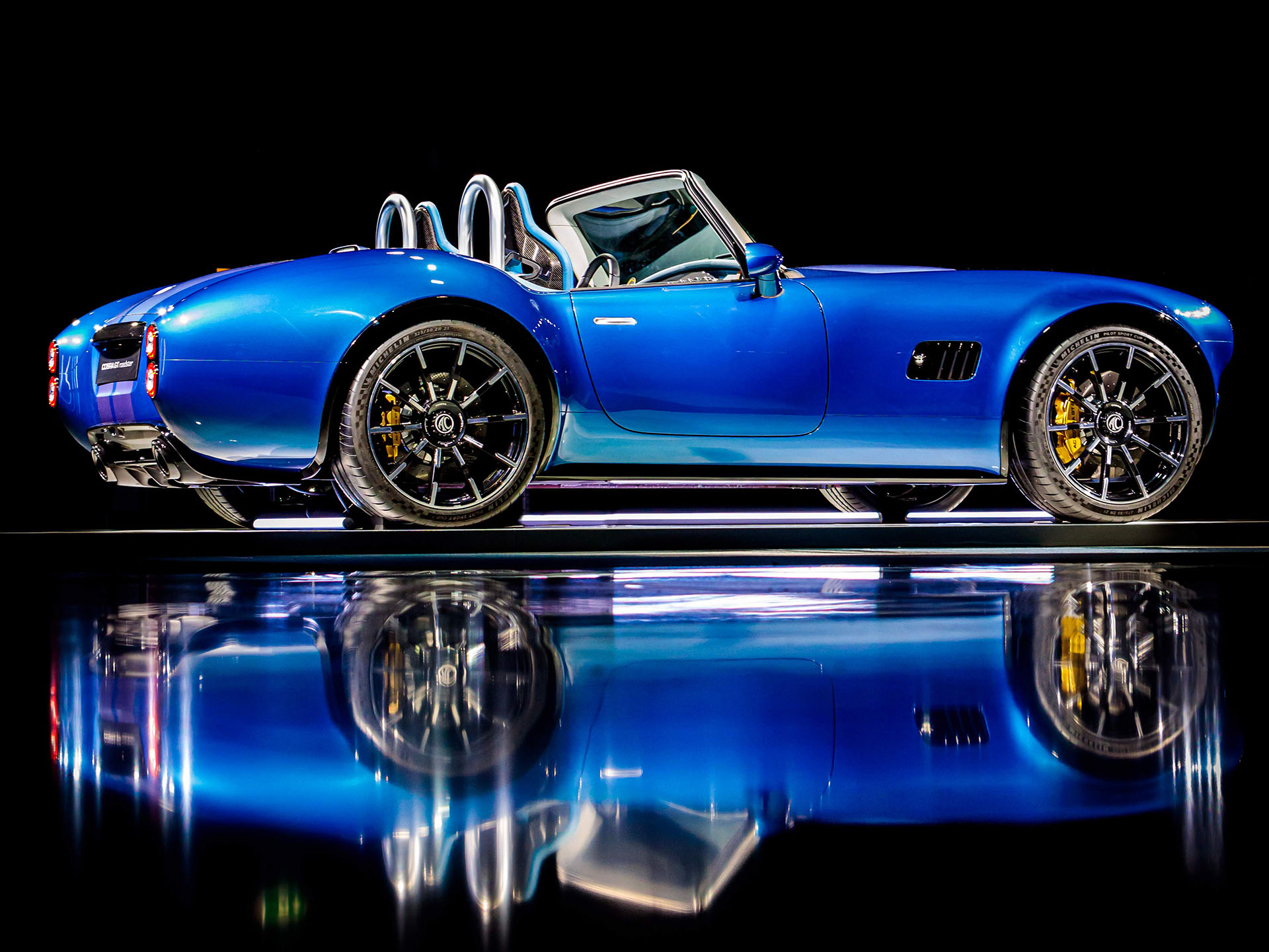 2024 AC Cobra GT Roadster in studio shot with dark background and mirror floor