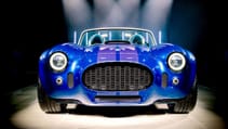 2024 AC Cobra GT Roadster in front facing studio shot with multiple spotlights pointing at it