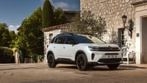 Static shot of C5 Aircross hybrid with sunlit residence in background