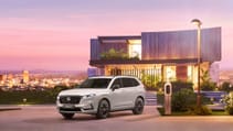 Front shot of all-new Honda CR-V in front of futuristic property during a purple sunset