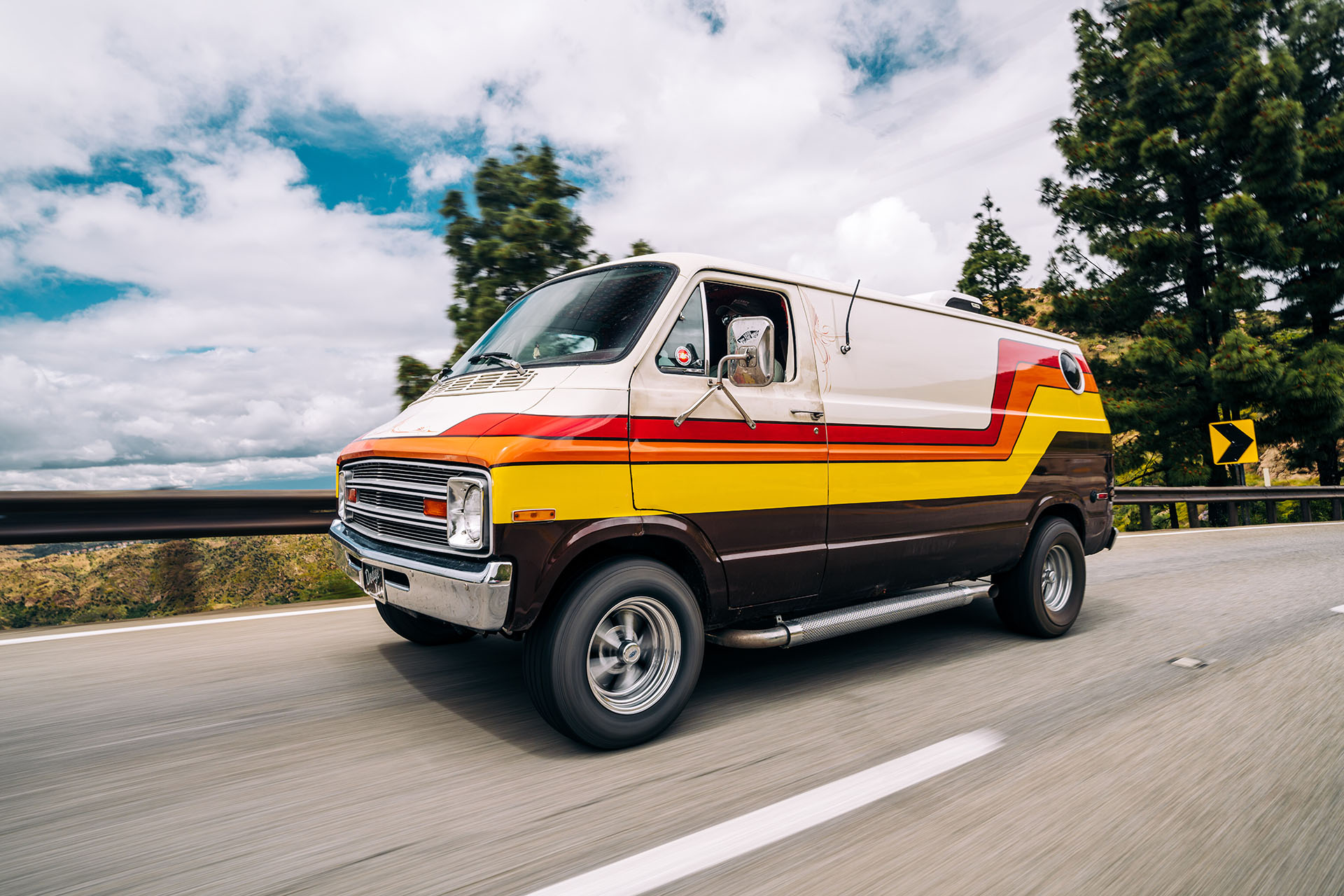 Driving shot of a 1977 Dodge Tradesman restored into a festival camper