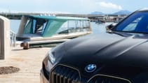 BMW Car with BMW Tyde Icon battery-electric boat docked in background