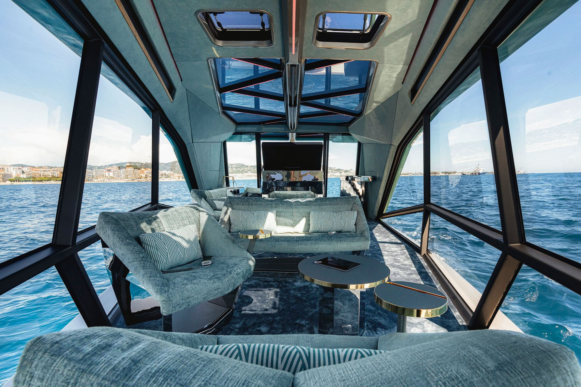 Internal shot of Icon's lounge with glass panels, glass ceiling and lounge chairs looking to back of boat