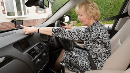 Woman reaching out to set her dash cam destination on the driveway