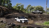 The 2024 Toyota Tacoma has been unveiled, this white one is coming round a curve on dirt tracks