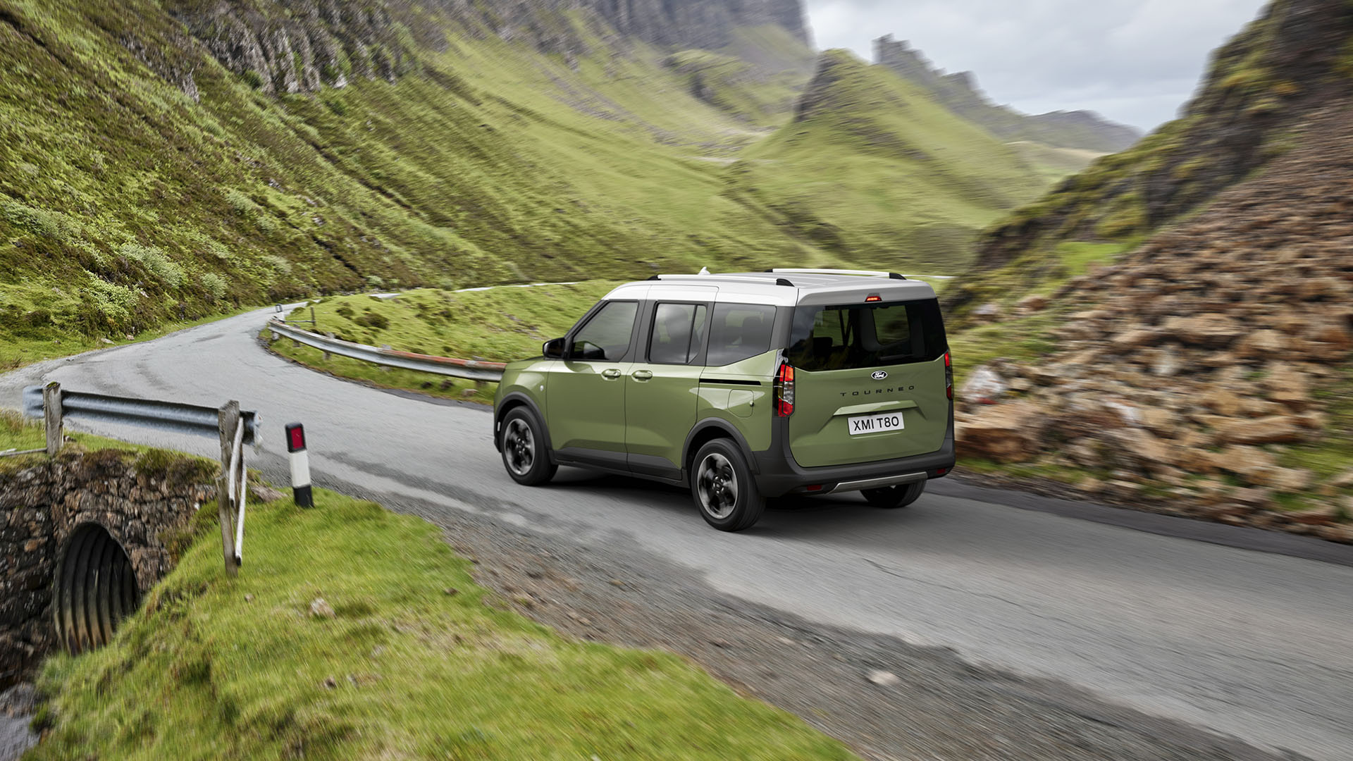 E-Tourneo Courier is latest in the electric line up from Ford. This green one seen driving on a road in a green grassy ravine