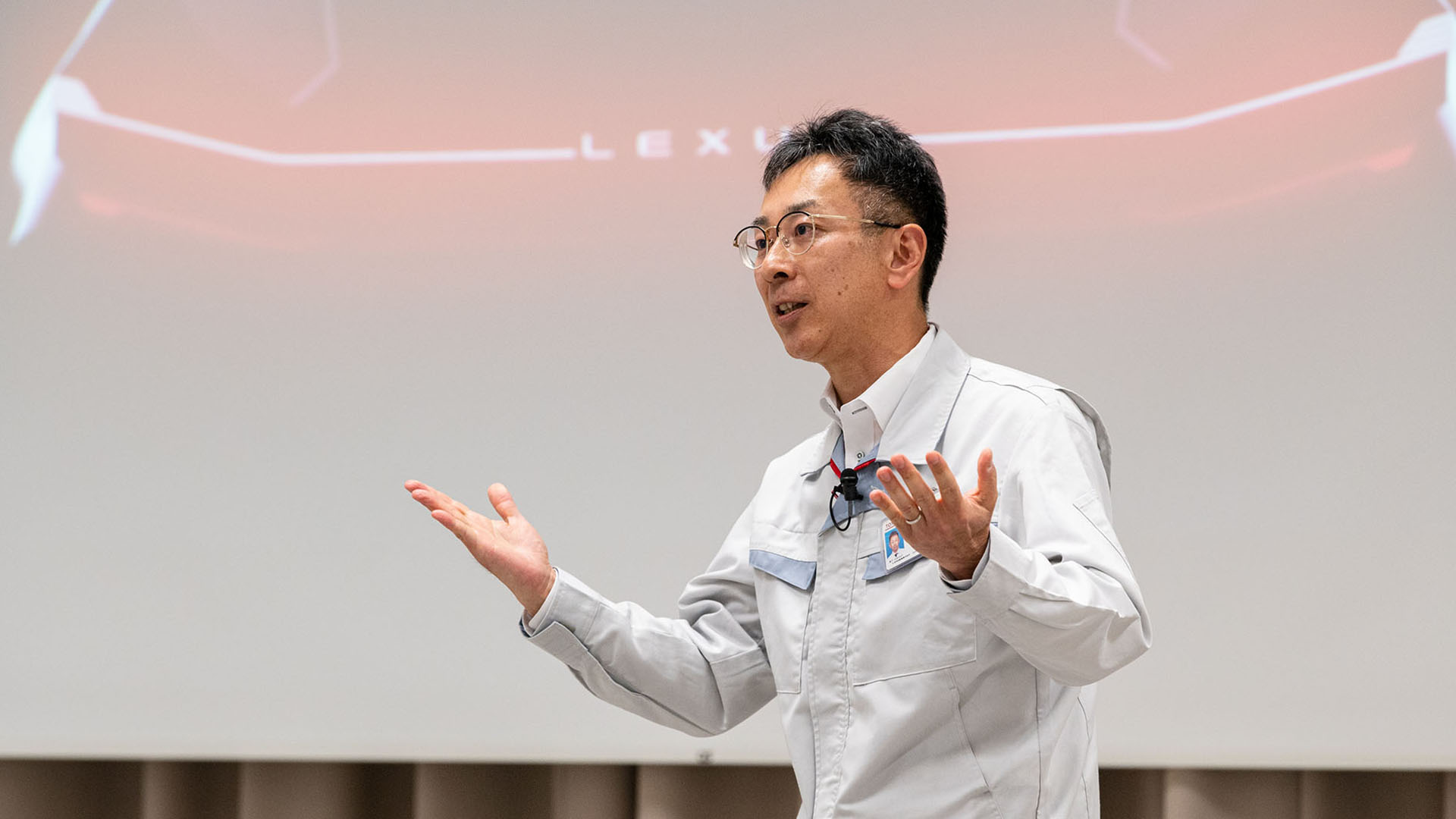 Takero Kato in BEV Factory division explaining how solid-state will move the needle in the future with video projector behind him