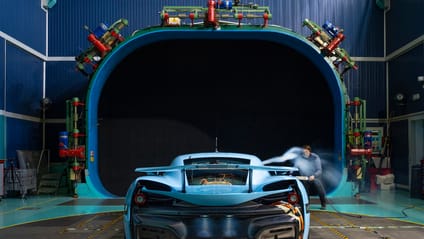 Rimac in front of a wind tunnel with engineer crouching to spray car