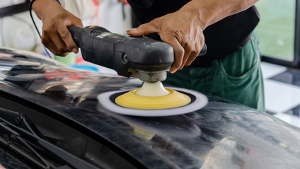 Someone trying to remove a scratch on a car bonnet 