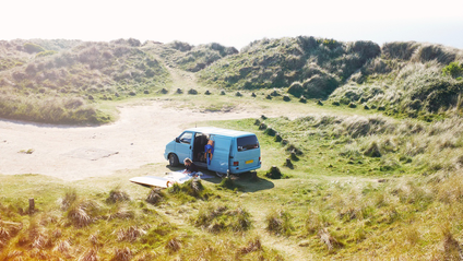 A campervan parked near a beach 