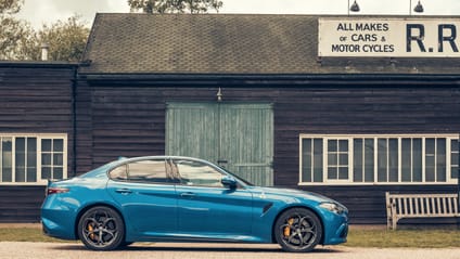 Alfa Romeo Giulia Quadrifolgio in side profile shot with old-school garage backdrop