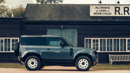 Defender in side profile shot with old-school garage backdrop