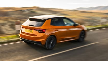 Driving shot of orange Skoda Fabia from the rear