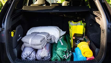 The boot of a Škoda Enyaq SUV packed with camping equipment 