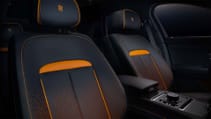 Static studio shot of Rolls-Royce Black Badge Ghost Ekleipsis both front seats with orange accents