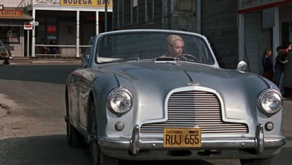 Tippi Hedren behind the wheel of a 1954 Aston Martin DB 2/4 Drophead Coupe