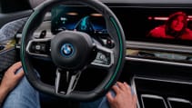 Interior shot of steering wheel showing man's hands on knees and movie playing on screen