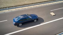 High angled shot of BMW 7 Series driving on road with pallet obstacle in front of car