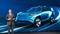 Nissan CEO Makoto Uchida standing in front of a digital presentation with a Nissan model in blue render