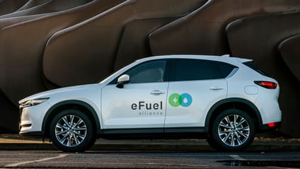 Mazda in side profile shot with decals on white car showing member of eFuel Alliance