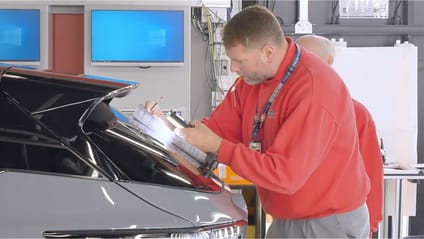 Nissan technican completing paperwork against boot lid