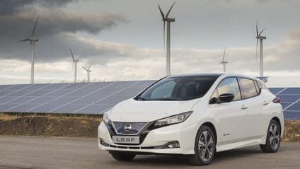 Nissan Leaf sitting in front of Nissan on-site wind farm