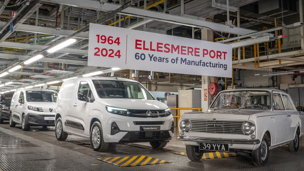 Factory floor of Ellesmere port with new electric vans on left and old school Vauxhall on right