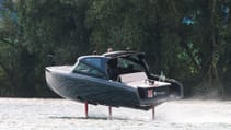 The Candela C-8 DC on water with hydrofoils deployed, banking around a corner, shot from rear